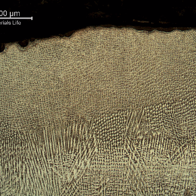 Micrography of the weld metal in the cap pass. A reheated pass is visible at the bottom.