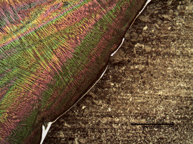 Micrography of the fusion line etched with Chromic Acid.  The weld metal (etched, dendritic) is in the left. There is a white layer that corresponds to planar solidification growth of the melted weld.