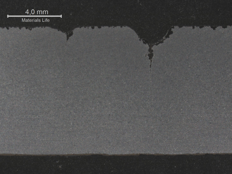Macrography of the longitudinal section of the pipe presenting multiple cracks from the tool marks.