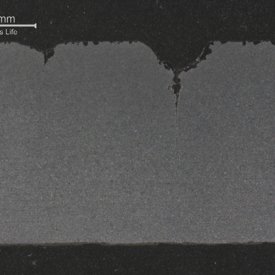 Macrography of the longitudinal section of the pipe presenting multiple cracks from the tool marks.