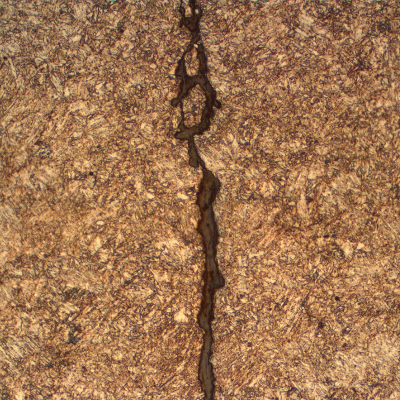 The micrography of one of the (multiple) cracks shows the slightly irregular morphology of the cracking, typical of a corrosion-fatigue mechanism.