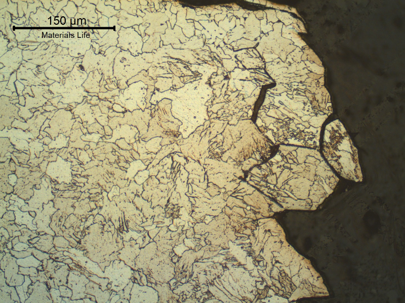 Micrography of the fractured region, from the superior plate side, showing that the intergranular cracking occurred at the coarse grain heat affected zone. The structure is bainitic and there are segregated regions in the previous austenite grain boundaries.