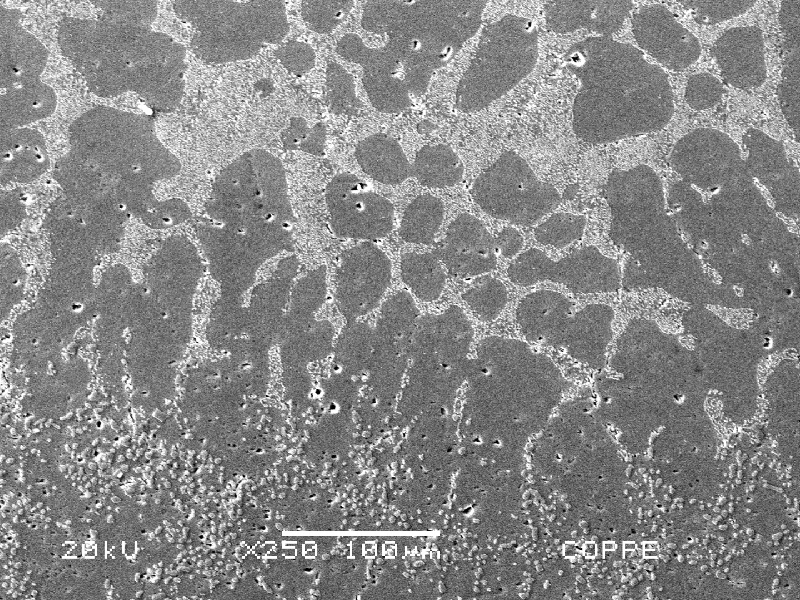 Low magnification micrography of the welded region, showing the interface between the base in the bottom and the fusion zone (between the liquidus and solidus temperatures), as well as the weld metal in the top.  There are pores close to the weld metal and in the fusion zone the interdendritic space was melted and the eutectic morphology was changed. Keller etch.