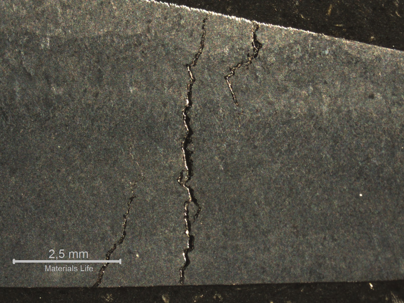 Macrographic aspect of a transverse section of the sample with multiple cracks that were deep in the weld metal.