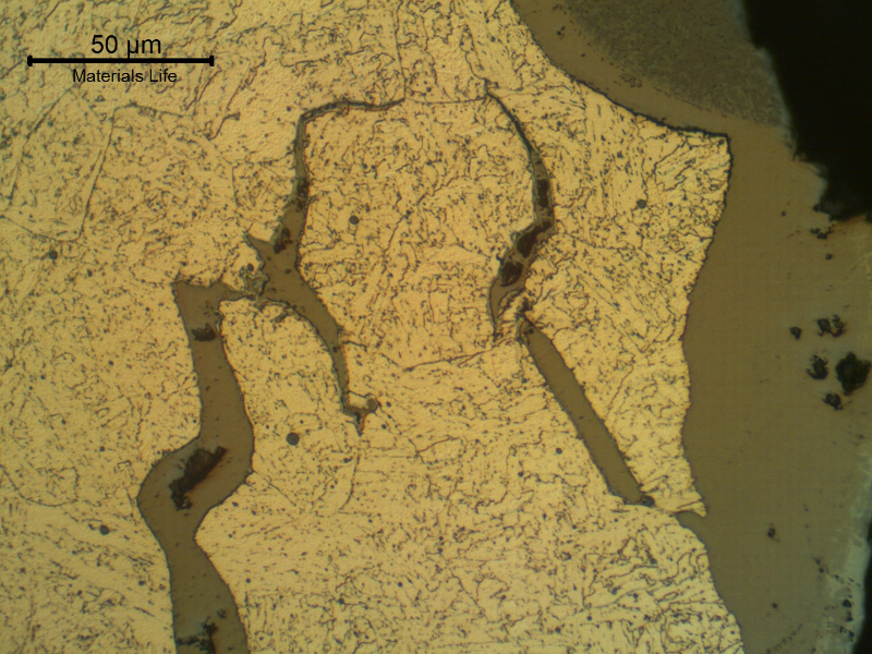 Micrographic details of opened cracks, filled with oxides.