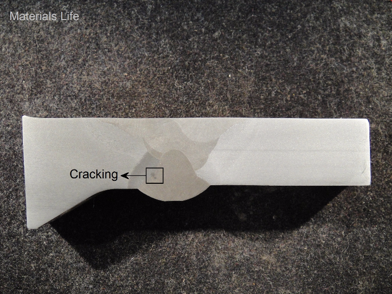 The macrography of a longitudinal section of the pipe and connector, at the welded joint, shows that the welding was conducted from both side of the groove, starting from the ID and finishing from the OD, ID later machined flush. The cracking was detected by ultrasonic test and the macro shows that it is at the fusion line, growthing into the weld metal. See the schematic drawing in the next figure