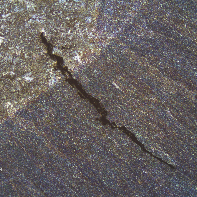 Micrography of the welded joint fusion line presenting the liquation cracking.  The weld metal is in the right side (bottom) and the forged connector heat affected zone is in the left side (top).