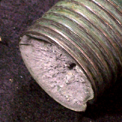 Macroscopic aspect of the stud that broke transverse to the axis, at the bottom of the thread fillet, presenting a brittle aspect.