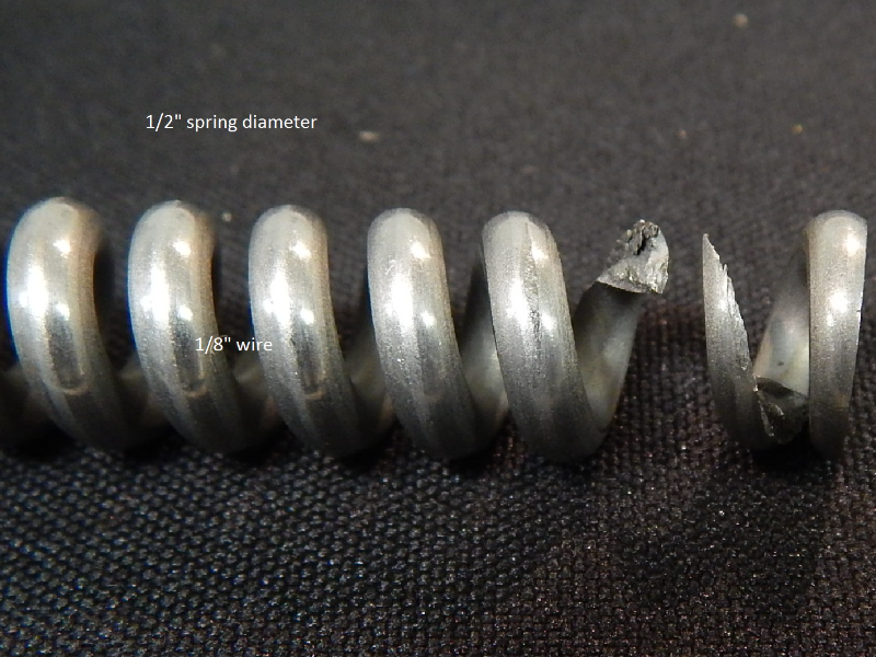 The stainless steel spring broke without any evidence of plastic deformation. The round wire 1/8" diameter has ruptured in a brittle way in this 2" long spring of external diameter of 1/2".