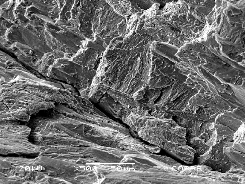 The fractography by SEM presents intergranular (in the previous austenite grain boundaries) and transgranular fracture micromechanisms.  Several secondary cracks perpendicular to the fracture surface.