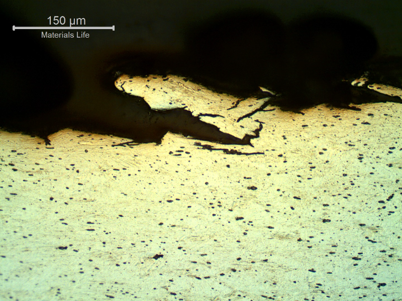 Micrography of a longitudinal section of the wire, at the fracture surface (top of the figure) evidencing the intergranular and transgranular aspects of the hydrogen assisted cracking mechanism.