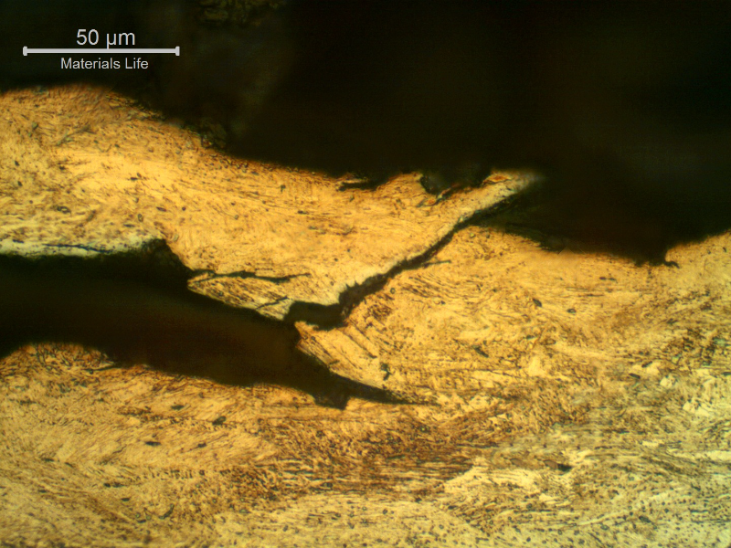 Micrographic detail of a longitudinal section of the wire, at the fracture surface (top of the figure) evidencing the intergranular and transgranular aspects of the hydrogen assisted cracking mechanism. The Kalling etch does not reveal the delta ferrite. Compare with the electrolytic oxalic acid etch in the other figure.