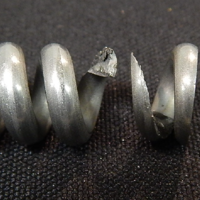 The stainless steel spring broke without any evidence of plastic deformation. The round wire 1/8" diameter has ruptured in a brittle way in this 2" long spring of external diameter of 1/2".