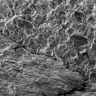 The low magnification fractography by SEM shows a brittle fracture of the spring wire, with several secondary cracks.
