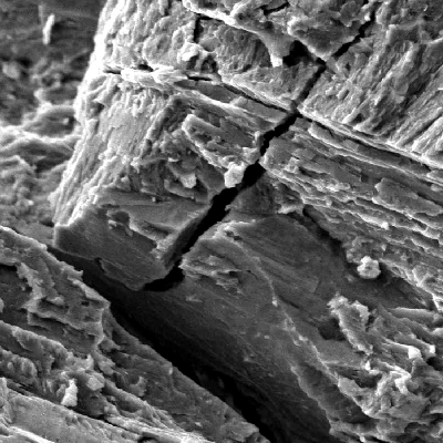The spring presents intergranular and transgranular brittle aspects in the fracture surface.