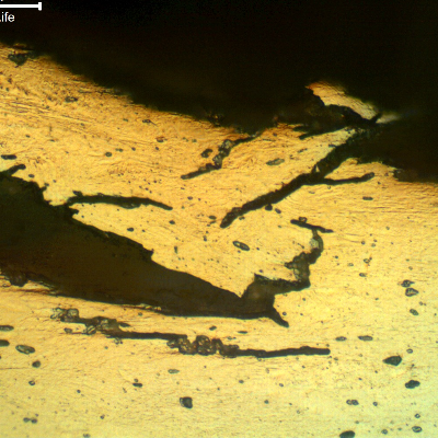 Micrographic detail of a longitudinal section of the wire, at the fracture surface (top of the figure) evidencing the intergranular and transgranular aspects of the hydrogen assisted cracking mechanism. The electrolytic oxalic acid etch reveals the delta ferrite phase.  Compare with the Kalling etch in the other figure.