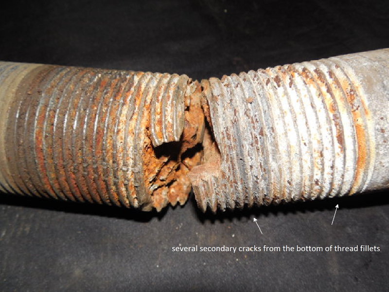 Aspect of the bolt fracture.  The fracture appearance is irregular and there are several secondary cracks from thread fillets.