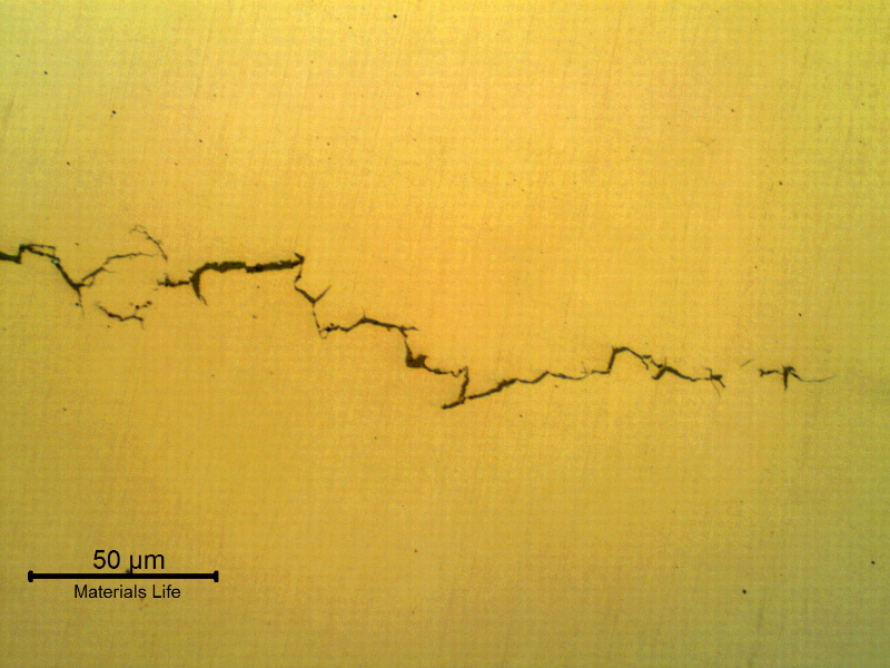 Micrography of a longitudinal section of the bolt, as polished, presenting brittle Intergranular and transgranular cracks, transverse to the bolt axis.