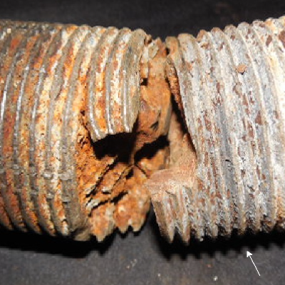 Aspect of the bolt fracture.  The fracture appearance is irregular and there are several secondary cracks from thread fillets.