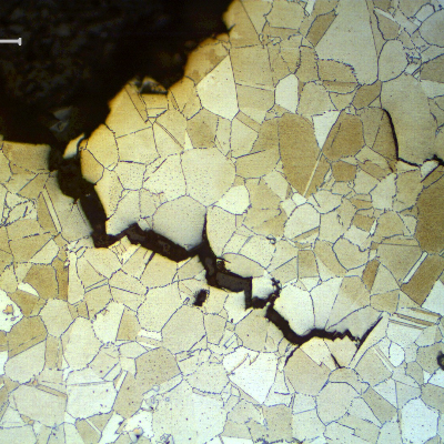 The micrographic detail of the longitudinal section at the fracture surface shows intergranular morphology for the secondary cracks (longitudinal to the forging axis).