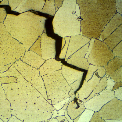 Micrographic detail of a longitudinal section of the connector, at the fracture surface (in the top), showing intergranular secondary cracks. There is a large amount of delta phase precipitated intergranular and intragranluar.