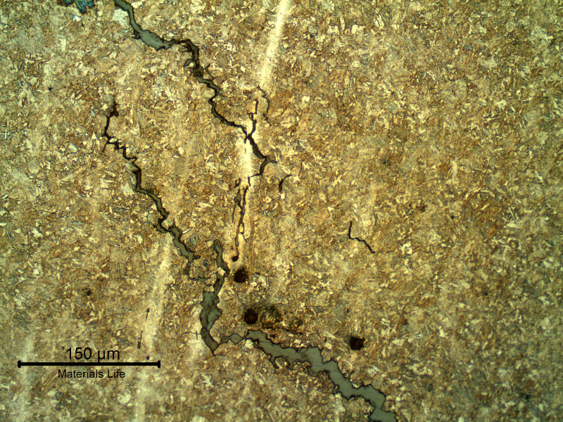 Micrography of the longitudinal section of the link, presenting secondary cracks in the longitudinal direction, following segregation bands in the material.