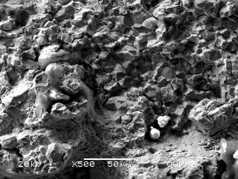 Fracture micromechanisms. Intergranular fracture in the top of the figure (close to the groove) and transgranular fracture in the bottom of the figure, where the mechanism changed to transgranular by quasecleavage.