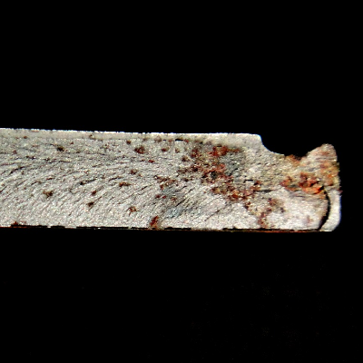 Macroscopic aspect of the fracture surface, showing a brittle behavior (chevron marks) and a starting point at the bottom of the groove in the right side of the figure.