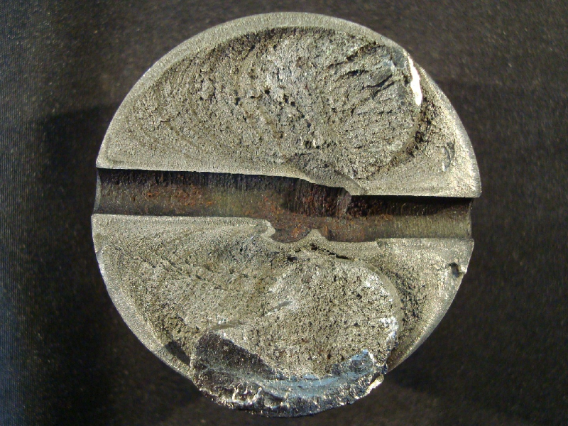 The aspect of the pin fracture surface shows that a fatigue crack propagated from the pin surface at the edge of a lubrication hole in the chromium plated pin.