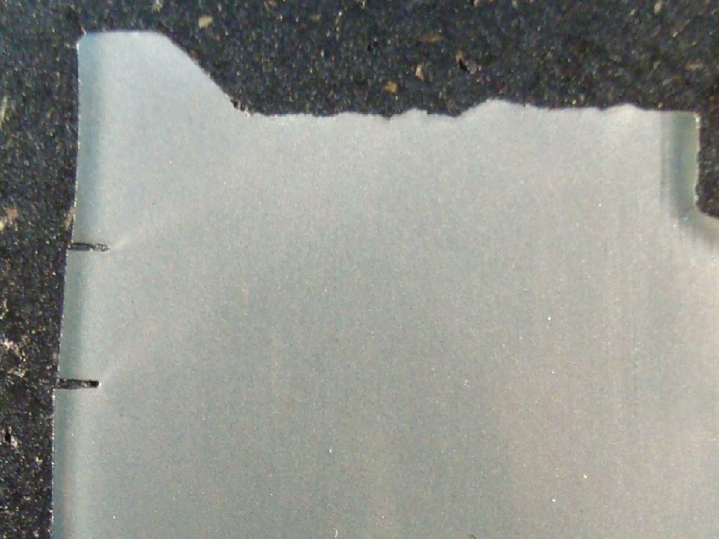 Macrography of the longitudinal section of the 2" diameter pin close to the fracture surface (top of the figure) in a section where the pin presented the final fracture (it is deformed). The lubrication hole is in the right side of the figure. It is possible to see several secondary cracks at the surface of the pin (left side of the figure), propagating only where there is a carburized layer. It is possible to see that the end of each secondary crack is blunted.