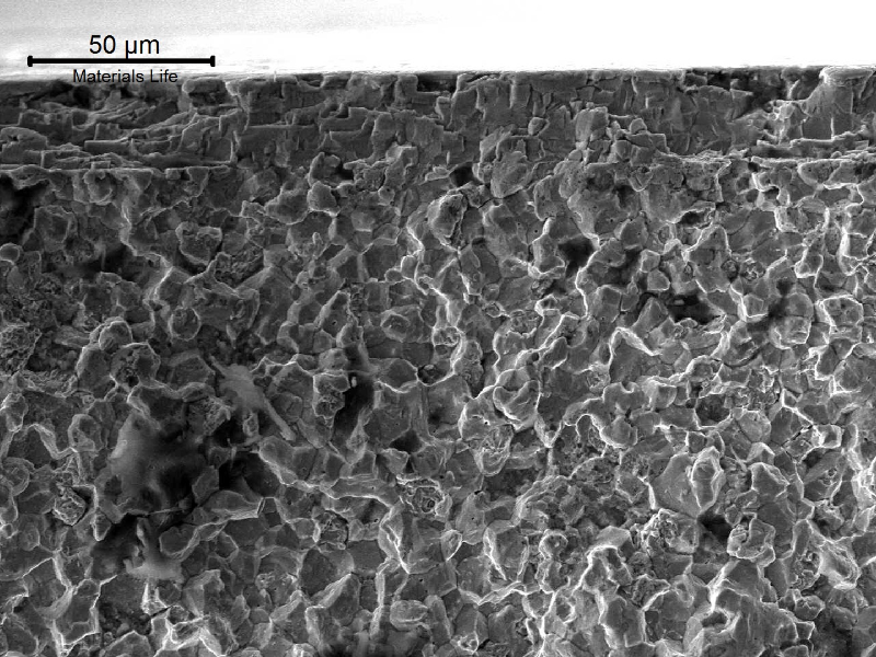 Scanning electron fractography showing that the fracture micromechanism is intergranular close to the surface of the pin, suggesting a hydrogen embrittlement effect at the carburized layer. The cracks were created during the electrolytic plating, and propagated later during service.