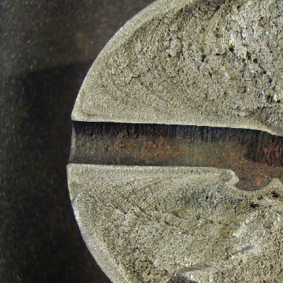 The aspect of the pin fracture surface shows that a fatigue crack propagated from the pin surface at the edge of a lubrication hole in the chromium plated pin.