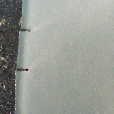 Macrography of the longitudinal section of the 2" diameter pin close to the fracture surface (top of the figure) in a section where the pin presented the final fracture (it is deformed).  The lubrication hole is in the right side of the figure. It is possible to see several secondary cracks at the surface of the pin (left side of the figure), propagating only where there is a carburized layer.  It is possible to see that the end of each secondary crack is blunted.