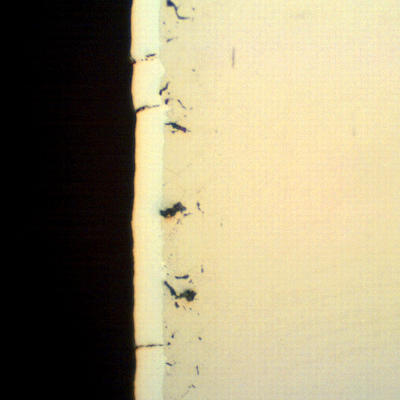 The as polished micrography of a longitudinal section of the pin, showing several microcracks associated to the chromium layer.