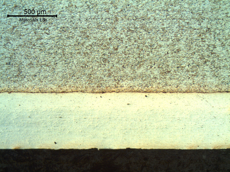 Micrography of a transverse section of the engine bearing, close to the internal surface, showing two layers of bearing alloys that presents a total thickness of 600 microns.