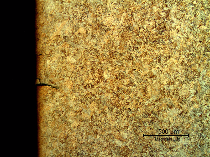Micrography of the pin in a longitudinal section, at the pin surface showing several secondary cracks, without plastic deformation, filled with products and branched.