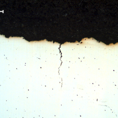 Micrography of the pin longitudinal section (transverse to the fracture), as polished. The fracture (in the top of the figure) is flat and it is possible to see secondary cracks with intergranular morphology.