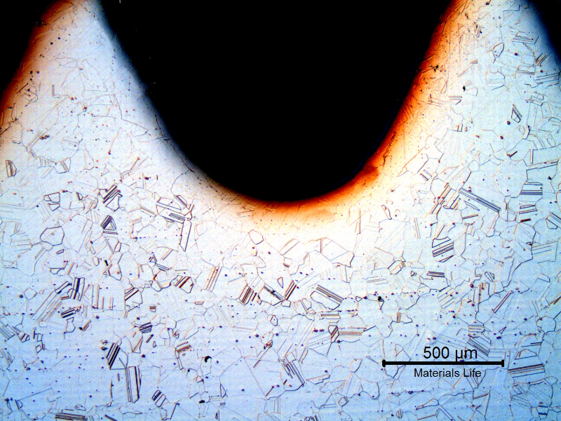 The micrography of a longitudinal section of the bolt close to the surface, at the thread, shows that it was machined from a bar, not rolled.