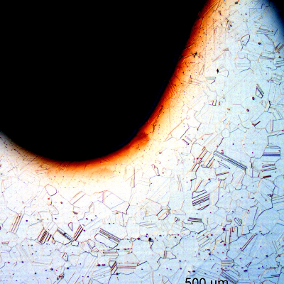 The micrography of a longitudinal section of the bolt close to the surface, at the thread, shows that it was machined from a bar, not rolled.