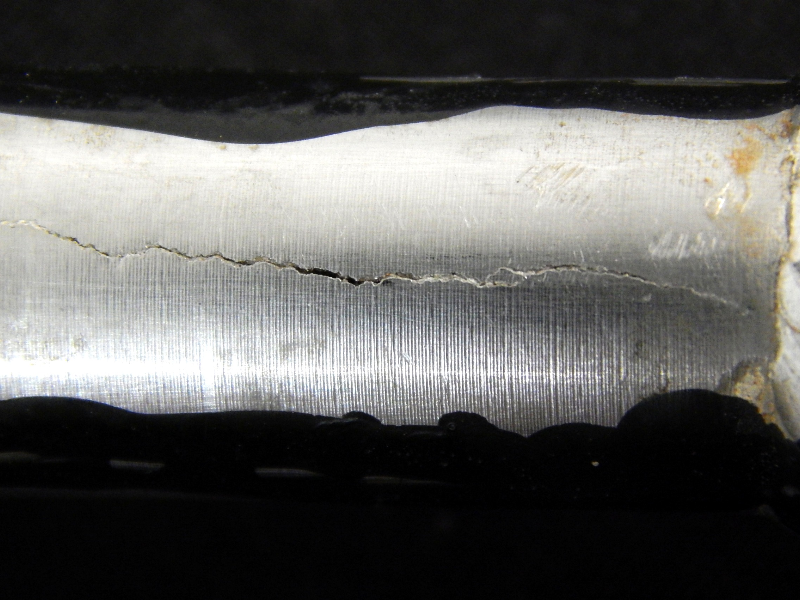 Detail of the longitudinal through wall cracking in the fitting welded to a tubing, ND 5/8"  in a hydraulic line.