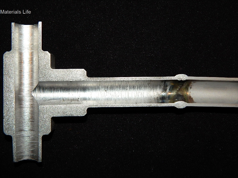 Macrography of a longitudinal section of the fitting to tubing weld, with the longitudinal cracking at the tubular fitting position.