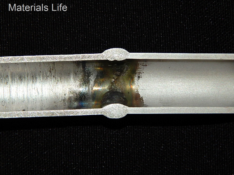 Macrography of the fitting to tubing welded joint. The internal surface of the fitting (left side) is rough compared to the internal surface of the tubing (right side). The cracking is located only in the fitting and presented no association with the welded joint.