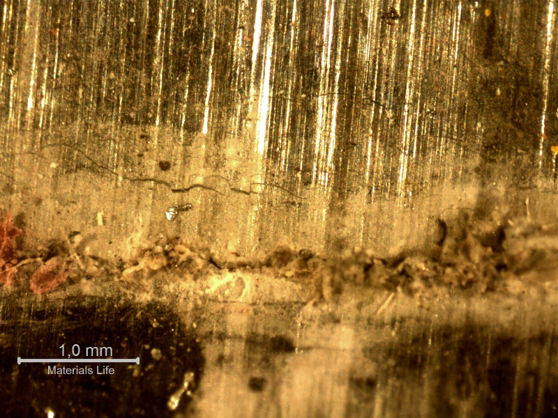 Aspect of the internal side of the fitting, at the cracked position with corrosion products and several surface microcracks adjacent to the main crack.