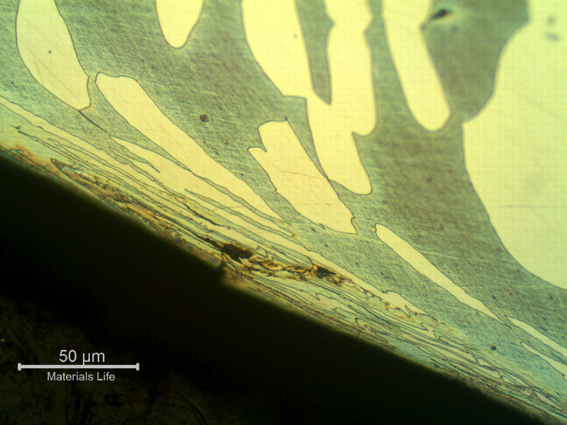 Micrographic detail of the region where the cracking was initiated at the internal side of the fitting. There are evidences of strain hadening efects, probably due to internal machining of the fitting, and surface microcracks.