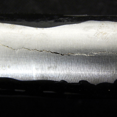 Detail of the longitudinal through wall cracking in the fitting welded to a tubing, ND 5/8"  in a hydraulic line.