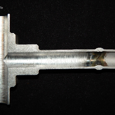 Macrography of a longitudinal section of the fitting to tubing weld, with the longitudinal cracking at the tubular fitting position.