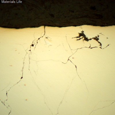 As polished micrography of the hydraulic line sample in the longitudinal section, close to the outer diameter, showing that the cracks are branched and thin, opened to the external surface.