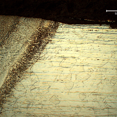 Micrography of the longitudinal section of the line at the fusion line of the fitting, close to OD. It is possible to see that the base metal is austenitic and the weld metal is austeno-ferritic.  In the center of the thickness the average hardness of the fitting is 250HV1 and the average hardness of the weld metal is 180HV1.