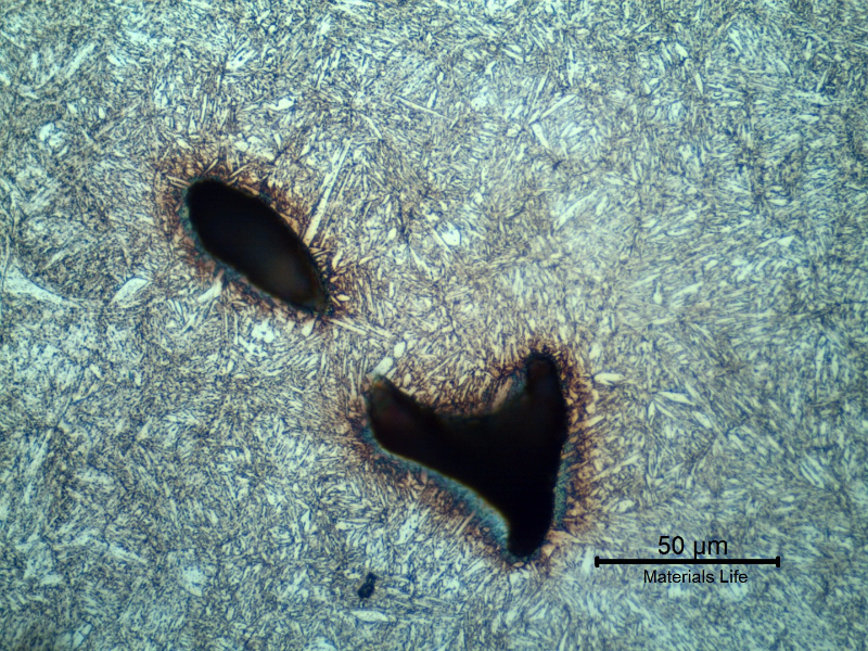 Micrography of the lifting padeye showing a quenched and tempered martensitic microstructure.  Voids are located in interdendritic segregated regions. At this magnification the segregation is not clear.