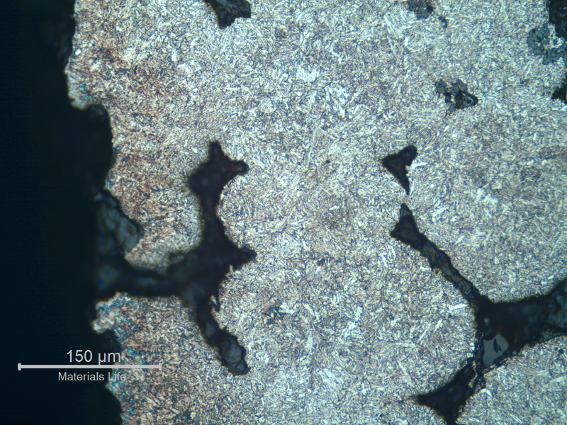 Micrographic detail of a region with a large amount of casting defects. Shrinkage voids in interdendritic spaces, some interconnected and cracked.